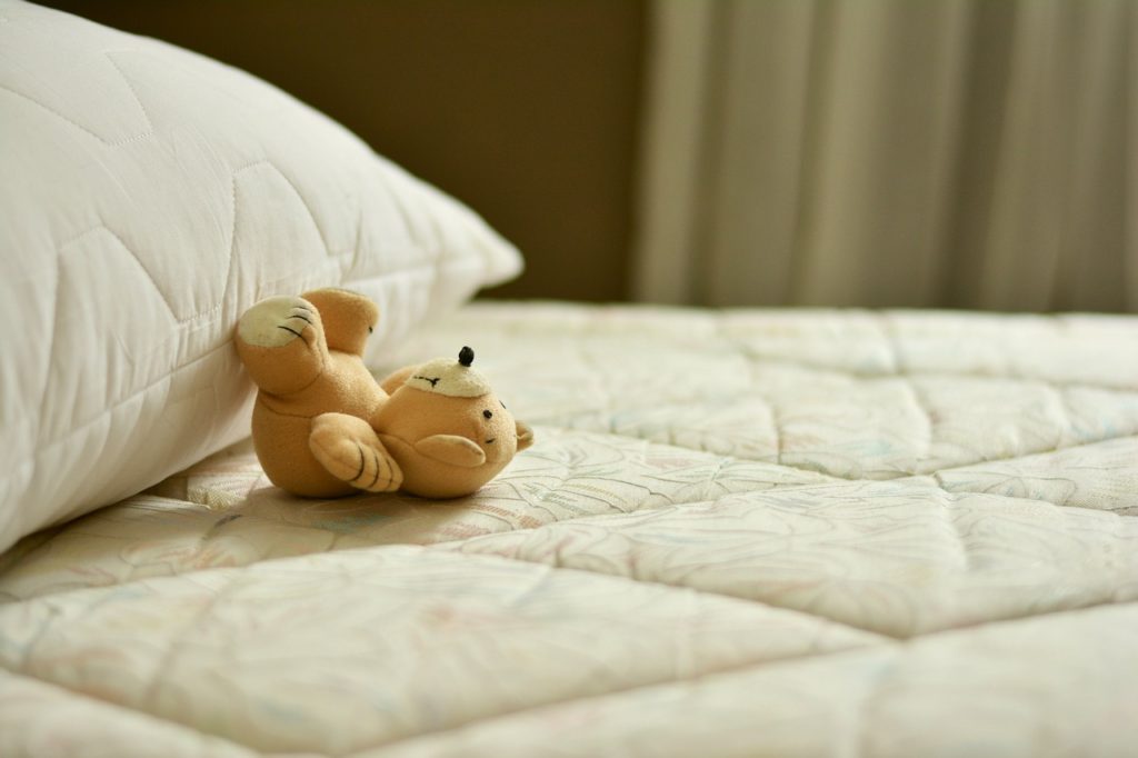 ベッドにクマのぬいぐるみ